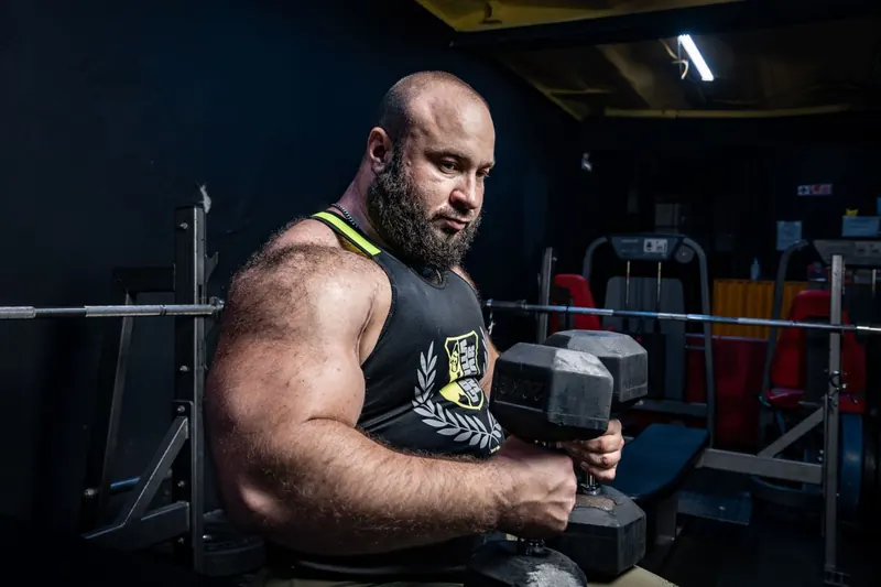 Professor orientando aluno na área de musculação de uma academia