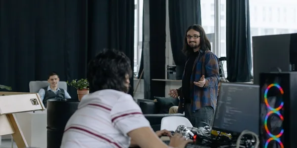 Equipe de desenvolvedores trabalhando em computadores em um escritório de tecnologia