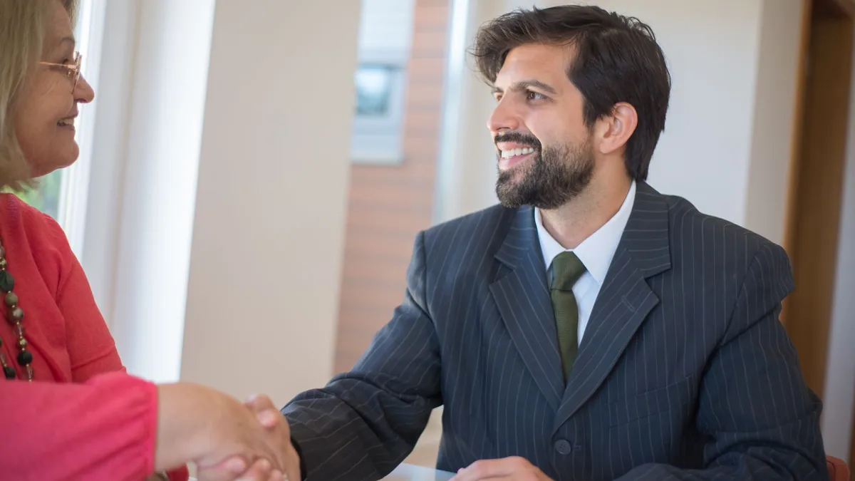 Representante comercial cumprimentando uma cliente ao fechar o pedido.