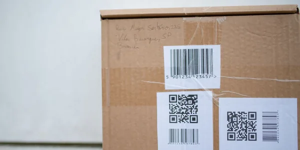 Caixa com código de barras e QR code, representando os códigos de classificação tributária do IBS e da CBS