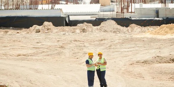 Engenheiro com capacete acompanhando obra em canteiro de construção