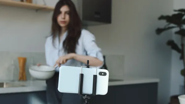 Criadora de conteúdo gravando um vídeo com o celular em tripé