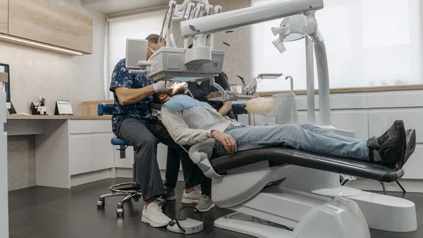 Dentista atendendo um paciente na cadeira odontológica