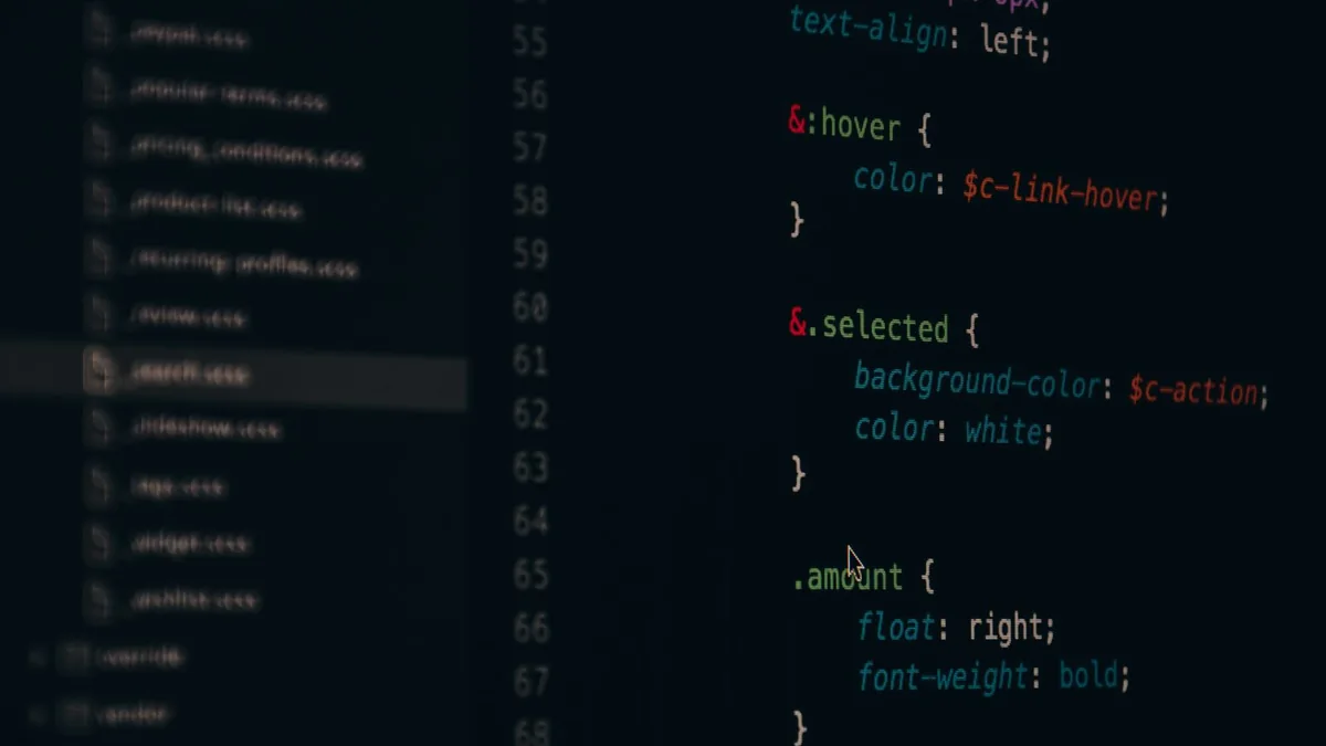 Desenvolvedor escrevendo código em dois monitores em uma mesa de trabalho
