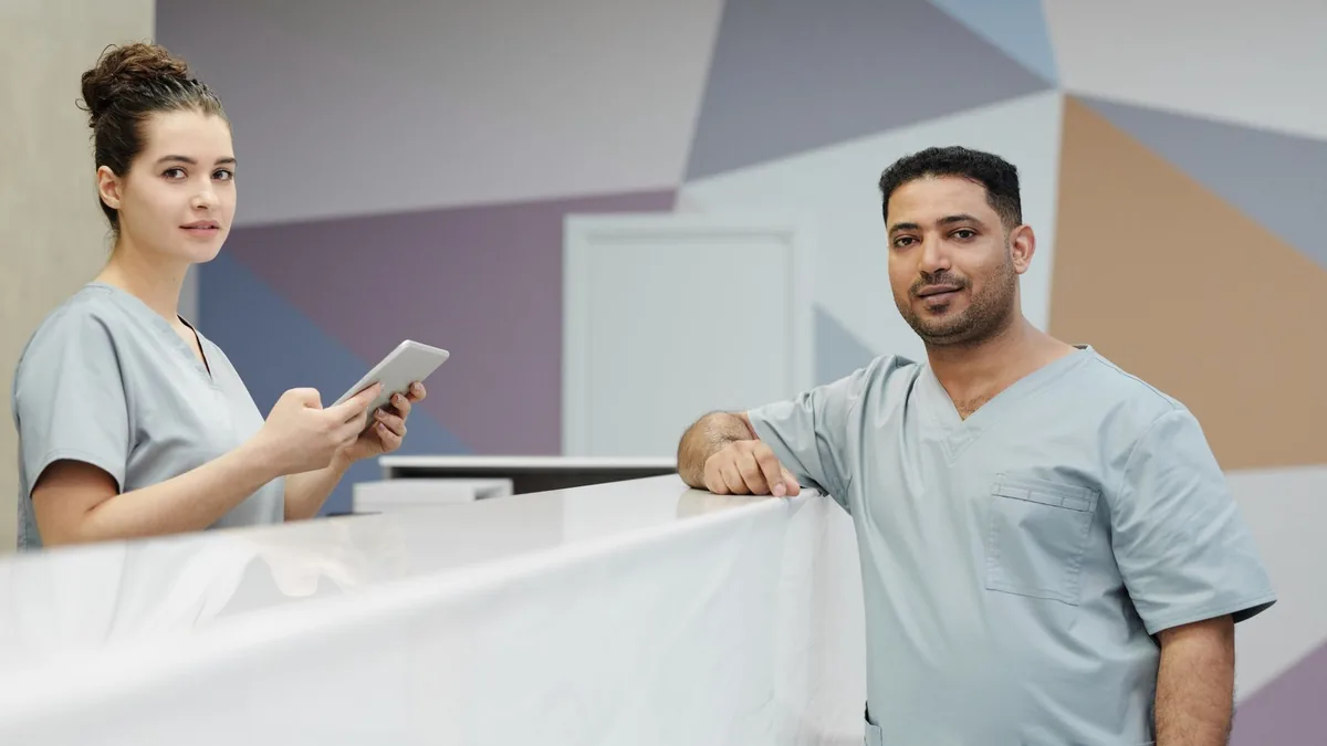 Recepcionista de clínica organizando prontuários em uma mesa de atendimento