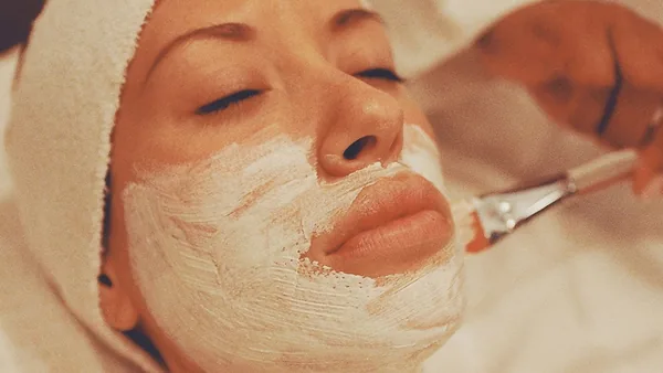 Profissional de estética aplicando um tratamento facial em uma cliente