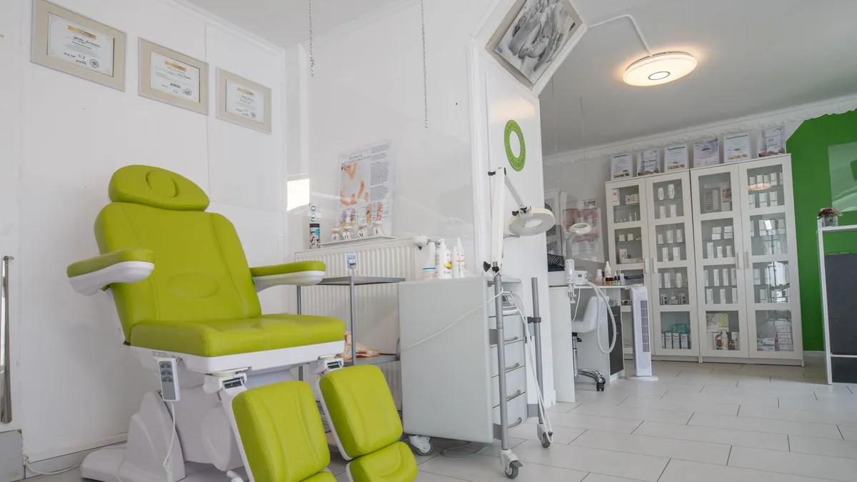 Esteticista aplicando um procedimento facial em uma cliente deitada na maca