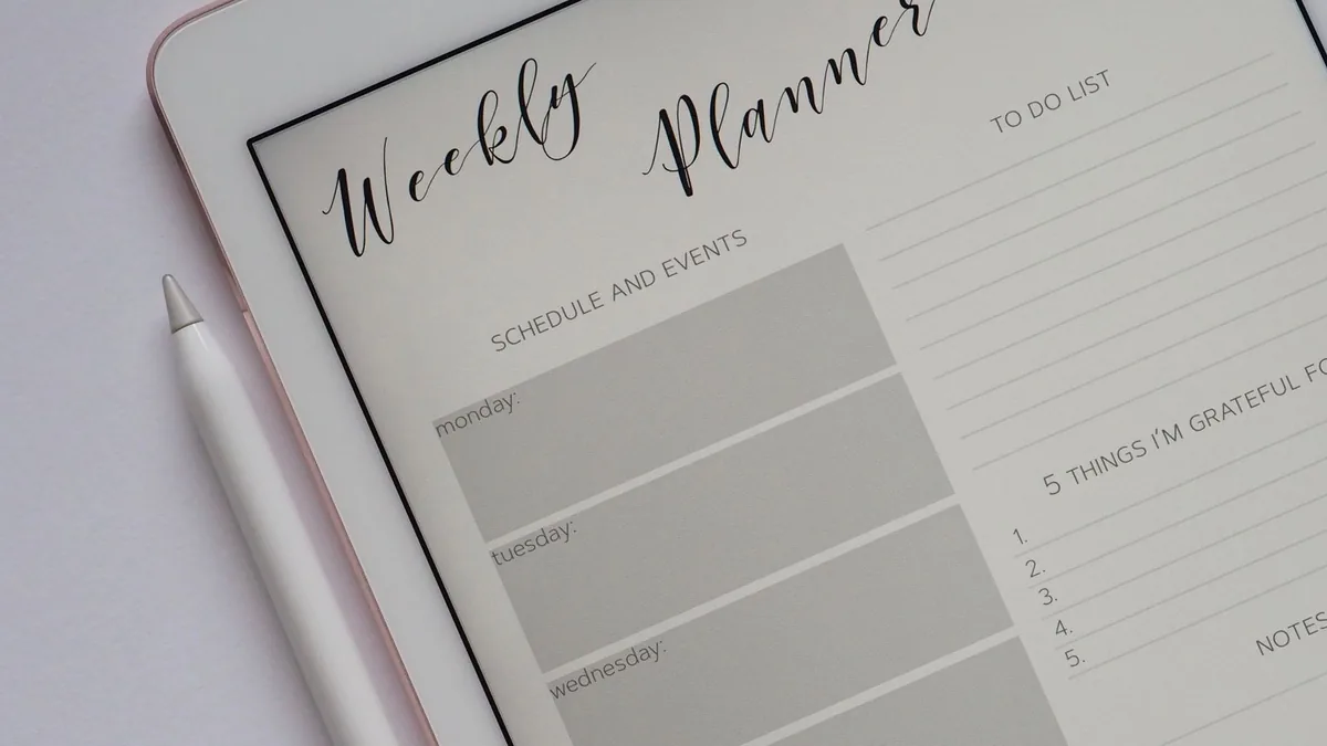 Profissional de estética conferindo agenda em um tablet no balcão da clínica