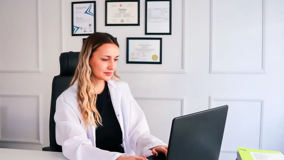Nutricionista anotando dados em uma ficha enquanto conversa com uma paciente