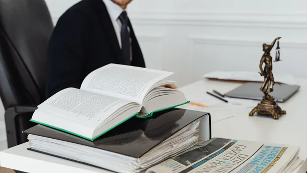 Advogado consultando livros de direito sobre a mesa do escritório