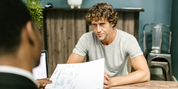 Dois profissionais conversando sobre documentos em um escritório contemporâneo