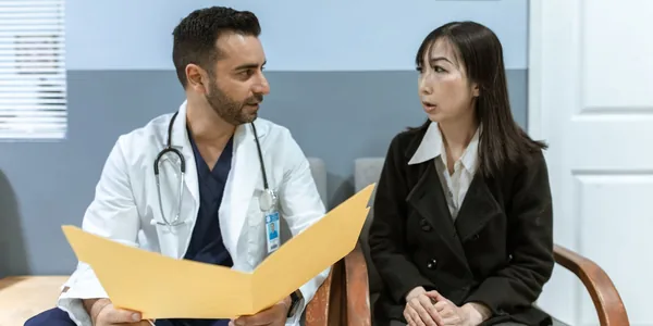 Profissional de saúde em consulta com um paciente no consultório