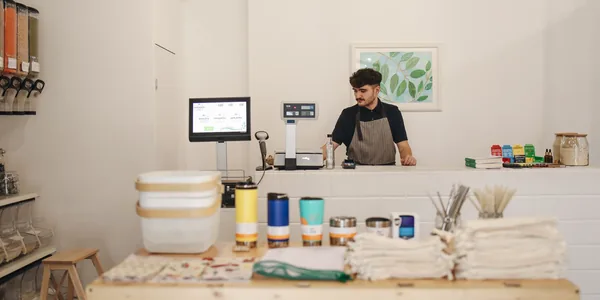 Jovem comerciante atendendo em uma loja de produtos a granel