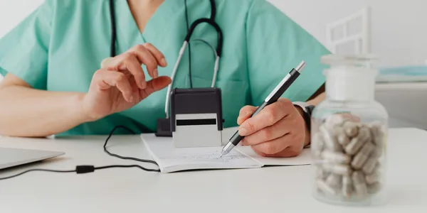 Profissional de saúde preenchendo uma prescrição no consultório