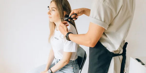 Cabeleireira cortando o cabelo de uma cliente em um salão moderno