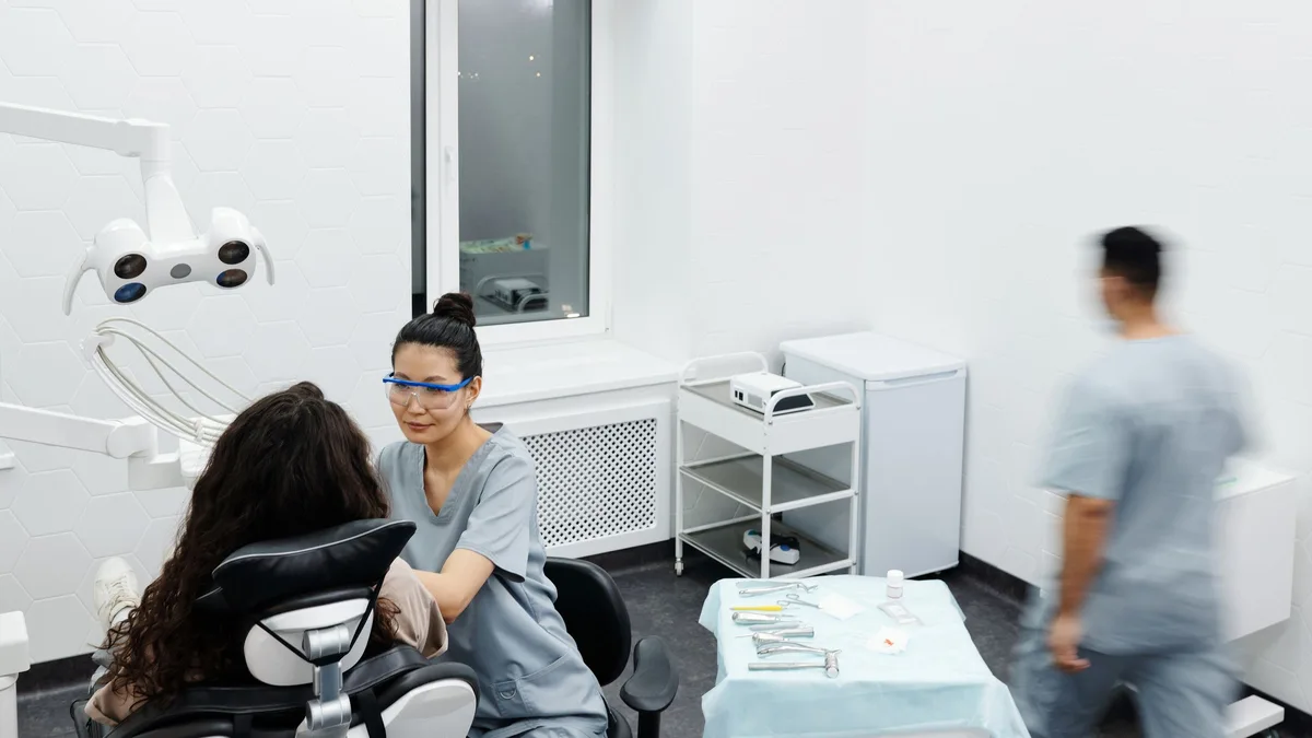 Dentista atendendo paciente em consultório equipado