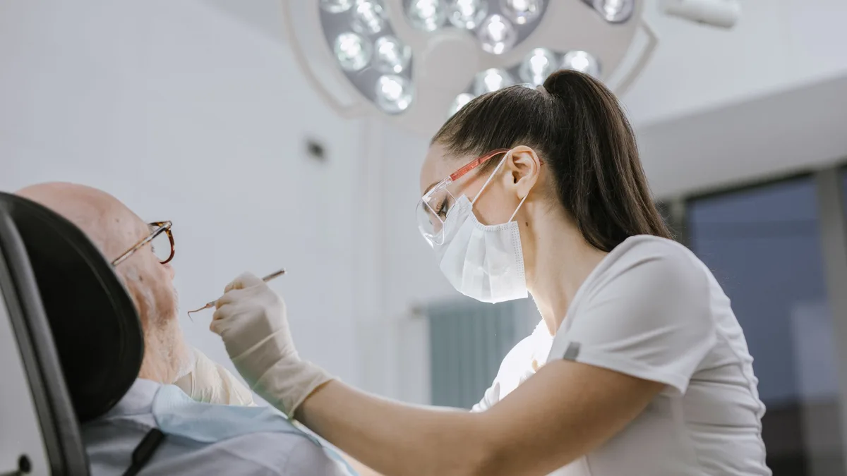 Dentista examinando um paciente na cadeira do consultório