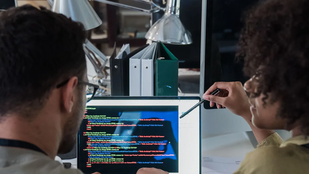 Equipe de desenvolvimento trabalhando junto em frente ao notebook