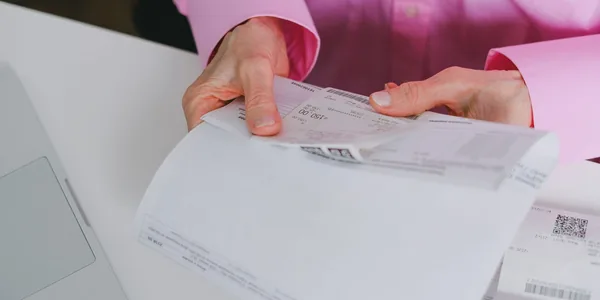 Pessoa organizando comprovantes e notas fiscais em papel