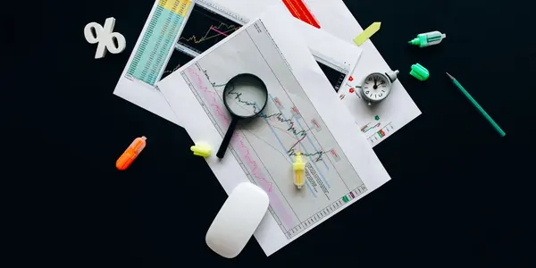 Mesa com calculadora, formulários fiscais e caneta, representando a conferência de declarações de uma empresa na malha fina