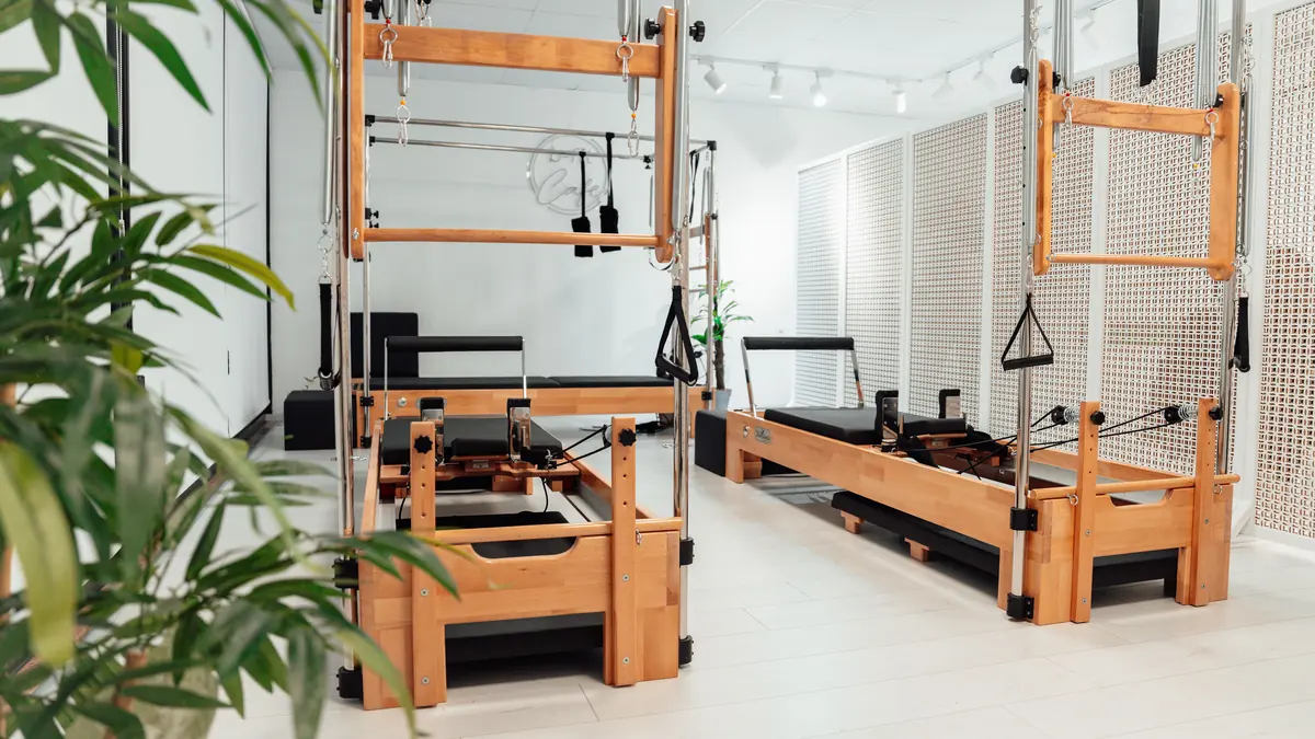Bright and spacious Pilates studio with wooden equipment in a white room, Yalova, Türkiye.