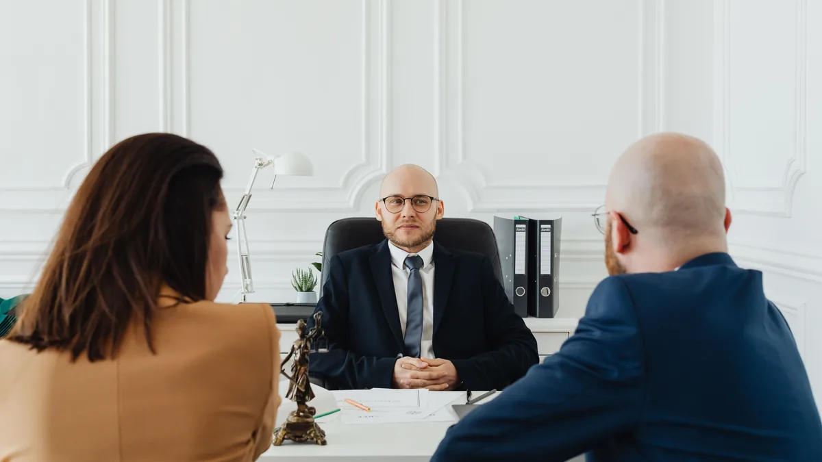 Lawyer meeting with clients in a formal office setting for legal consultation.