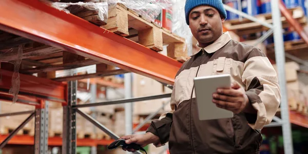 A warehouse employee scans items using a tablet, ensuring inventory accuracy.