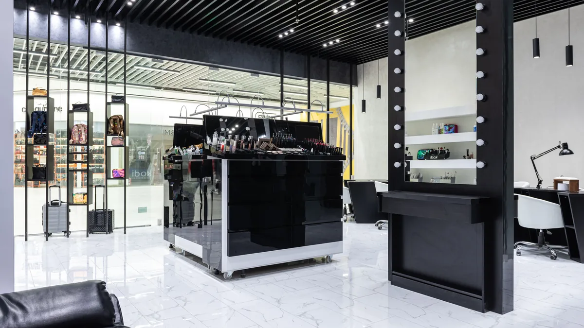 A sleek and modern salon with a central beauty product display and contemporary decor.