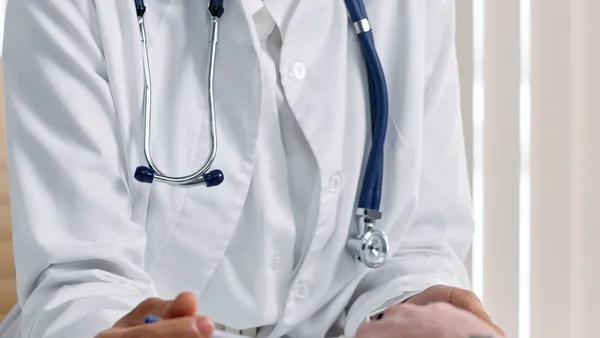 Médico conversando com paciente na mesa do consultório