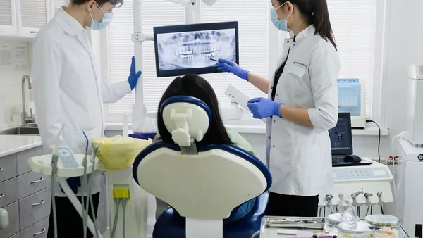 Dentista atendendo em consultório odontológico equipado