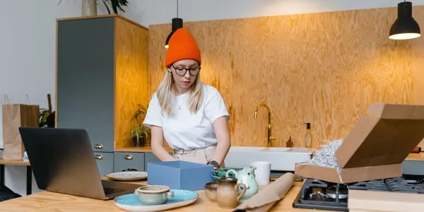 Empreendedora embalando peças artesanais para venda, representando a figura do nanoempreendedor