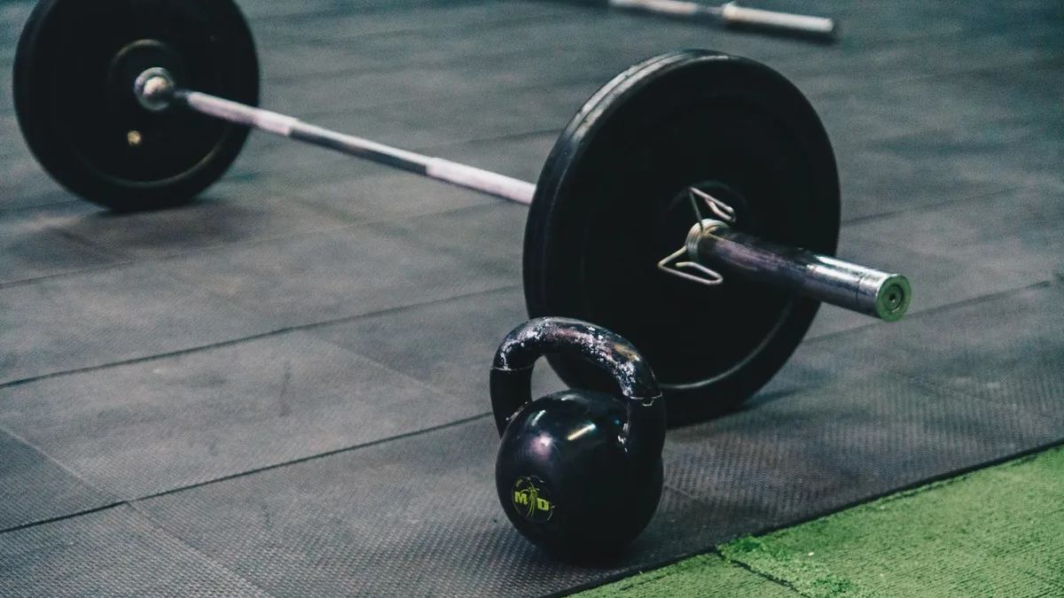 Barra e kettlebell sobre o tatame da academia