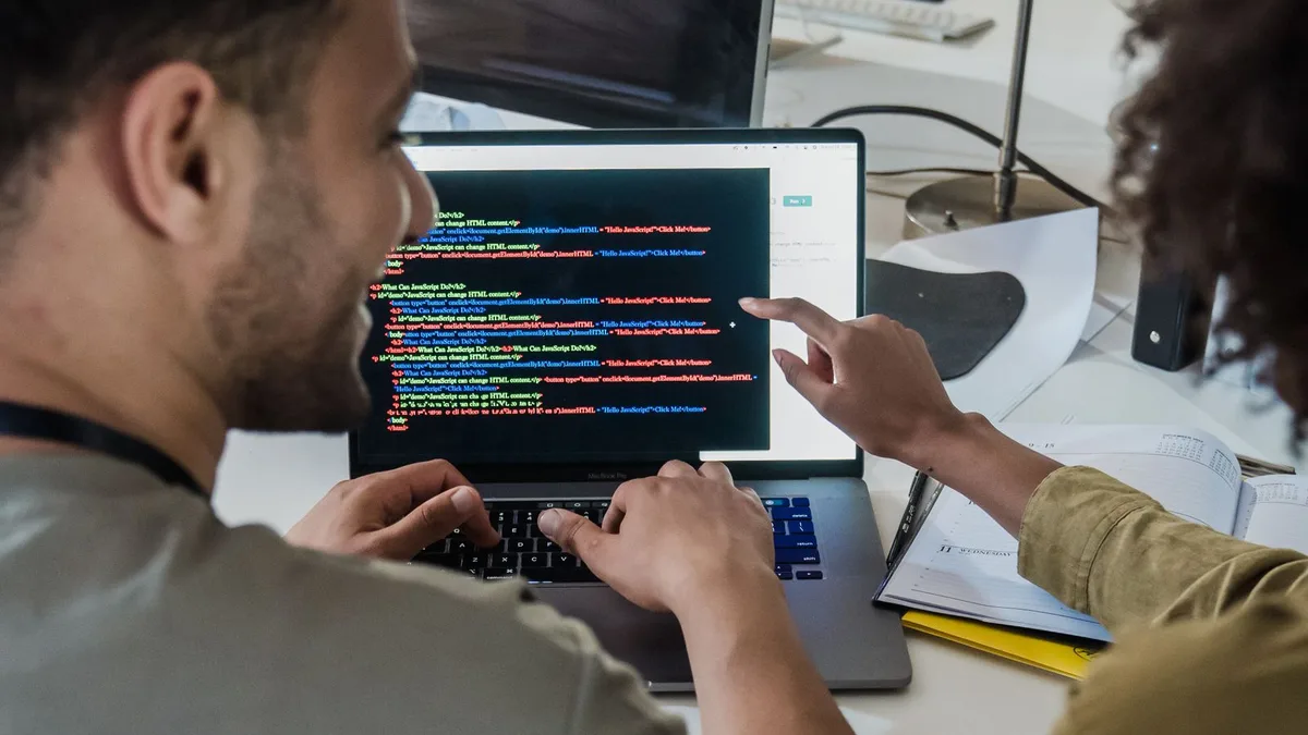 Dupla discutindo programação no escritório