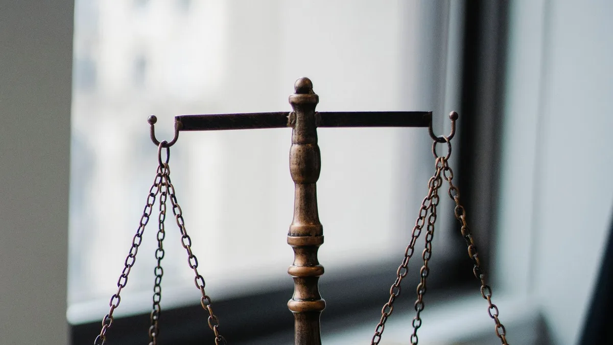 Balança da justiça e martelo sobre a mesa