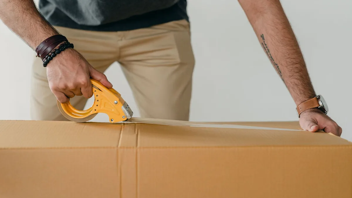 Caixa sendo lacrada com fita para envio