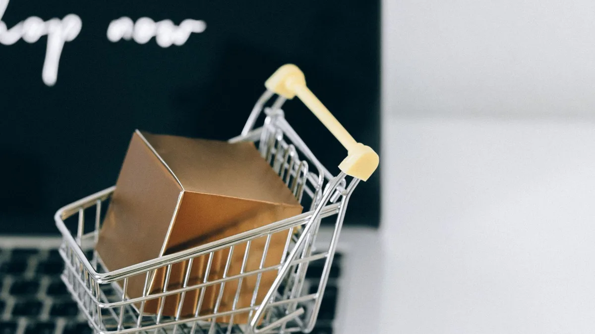Carrinho de compras em miniatura sobre o notebook