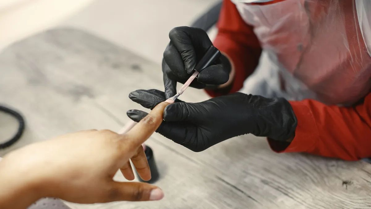 Manicure fazendo as unhas de uma cliente