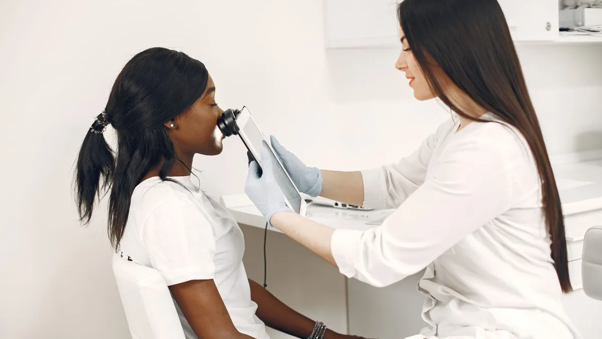 Profissional fazendo análise de pele com equipamento na clínica de estética