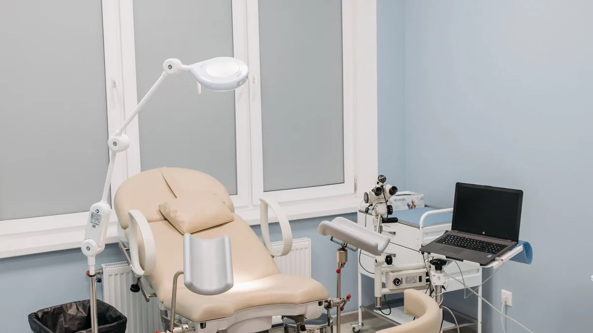 Sala de exame de uma clínica médica moderna, com maca e equipamentos