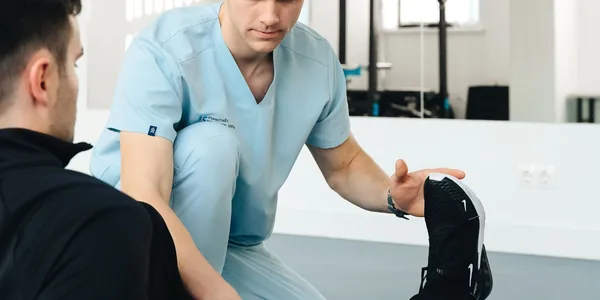 Fisioterapeuta atendendo um paciente durante a sessão de reabilitação