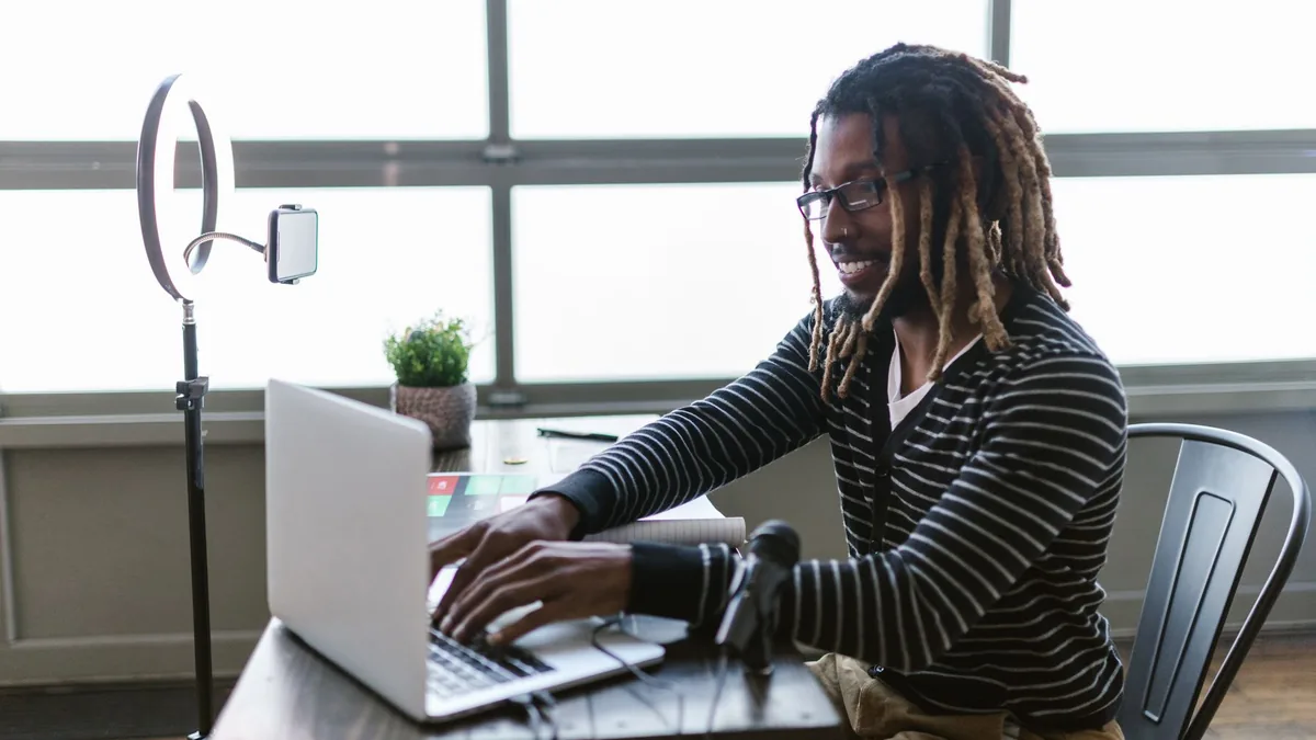 Criador de conteúdo trabalhando no notebook com iluminação de anel