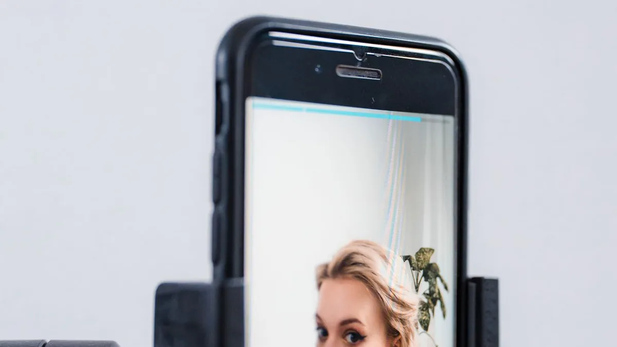 Celular preso ao trip&eacute; gravando uma criadora durante a produ&ccedil;&atilde;o de conte&uacute;do