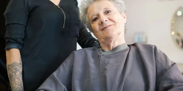 Cliente sendo atendida pela cabeleireira na cadeira do salão