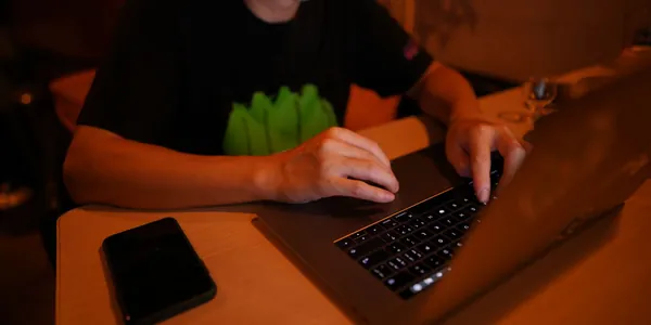 Profissional CLT trabalhando no próprio negócio depois do expediente