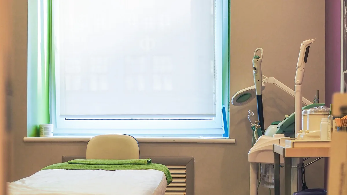 Sala de atendimento de clínica de estética com maca e equipamentos