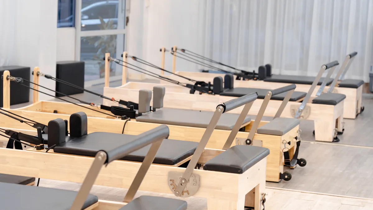 Estúdio de pilates com aparelhos alinhados e vazios.