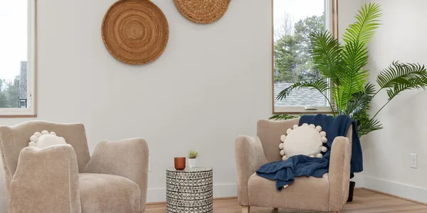 Sala de atendimento clara, com duas poltronas, planta e luz natural pela janela.