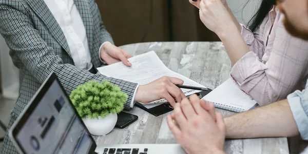 Reunião de negócios com notebooks e documentos sobre uma mesa rústica