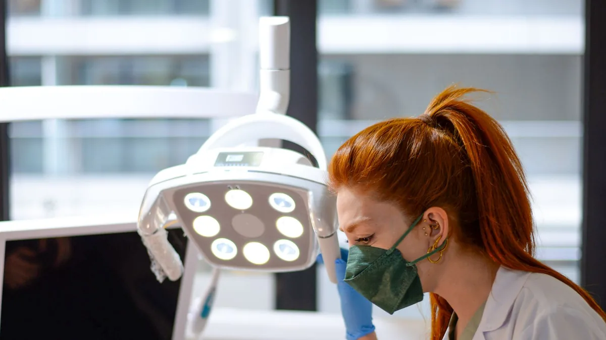 Dentista atendendo paciente em consultório odontológico equipado