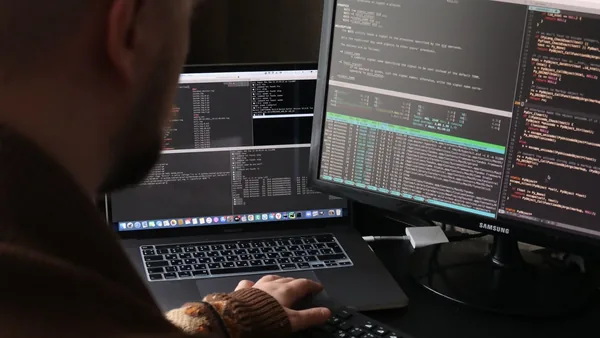 Desenvolvedor programando diante do monitor com o código aberto